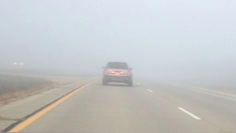 An Audi in very foggy conditions properly using rear fog lights (on either side of the license plate).